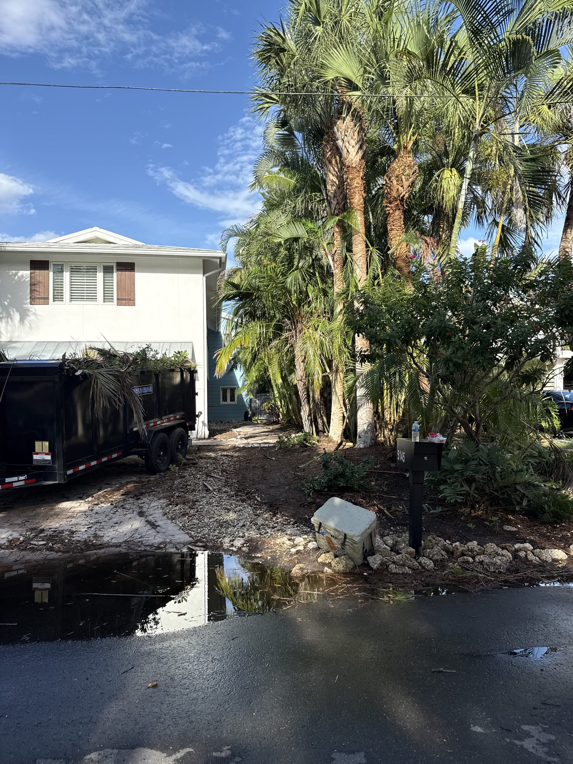 Before: cleanup day with a debris trailer in the driveway
