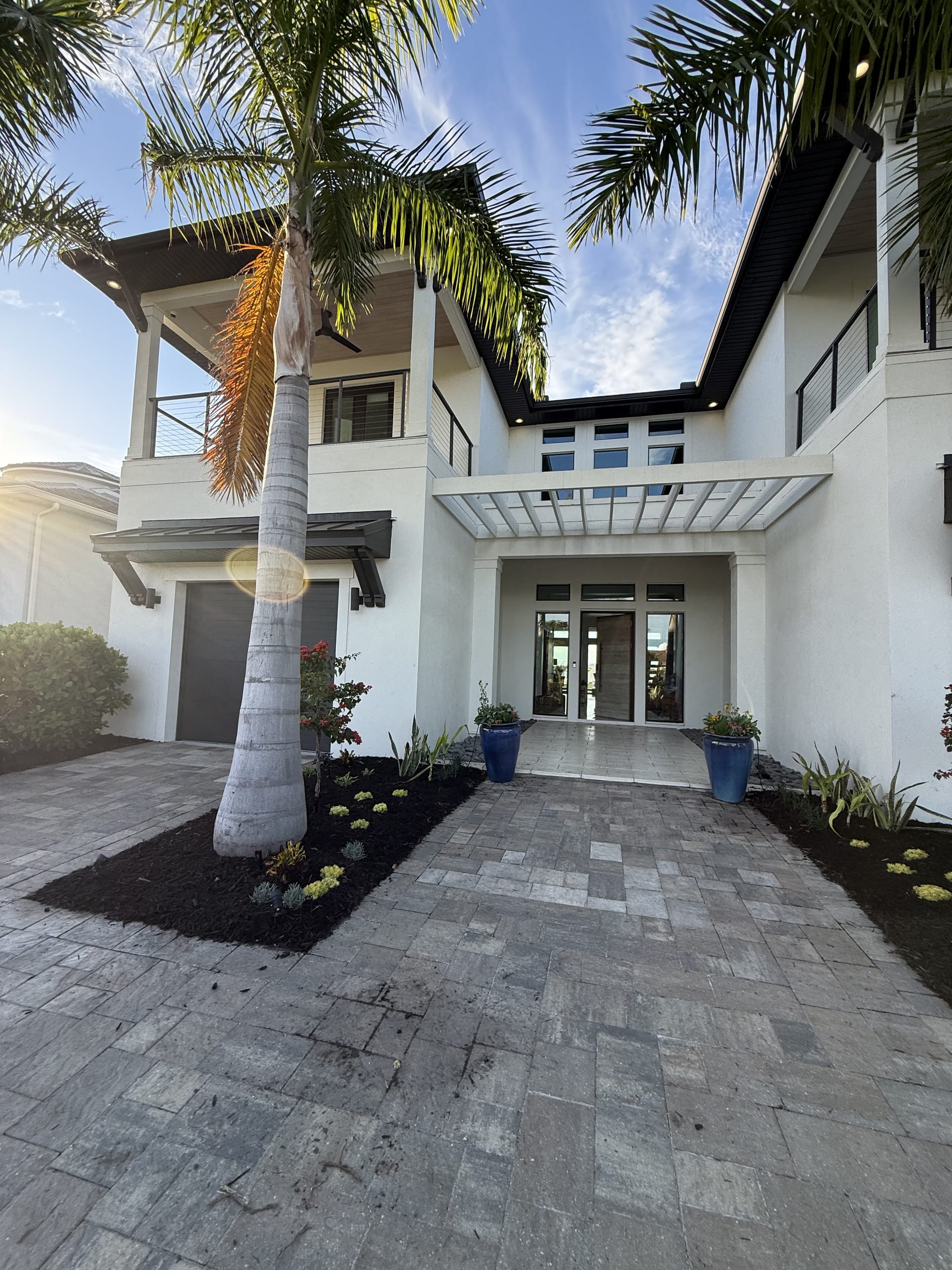 Modern luxury waterfront home with layered tropical landscaping