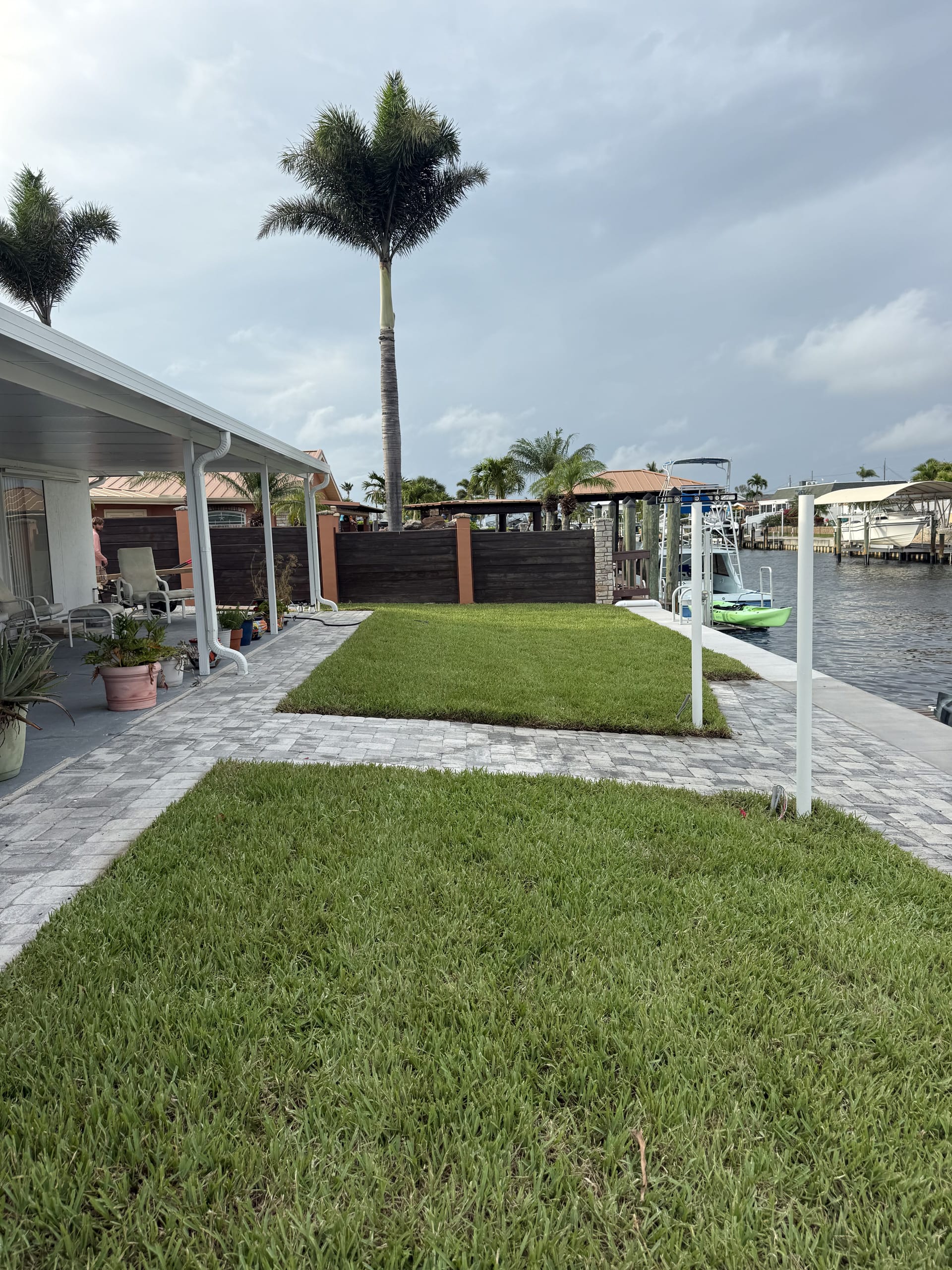 After: finished lawn and layered tropical beds along the water