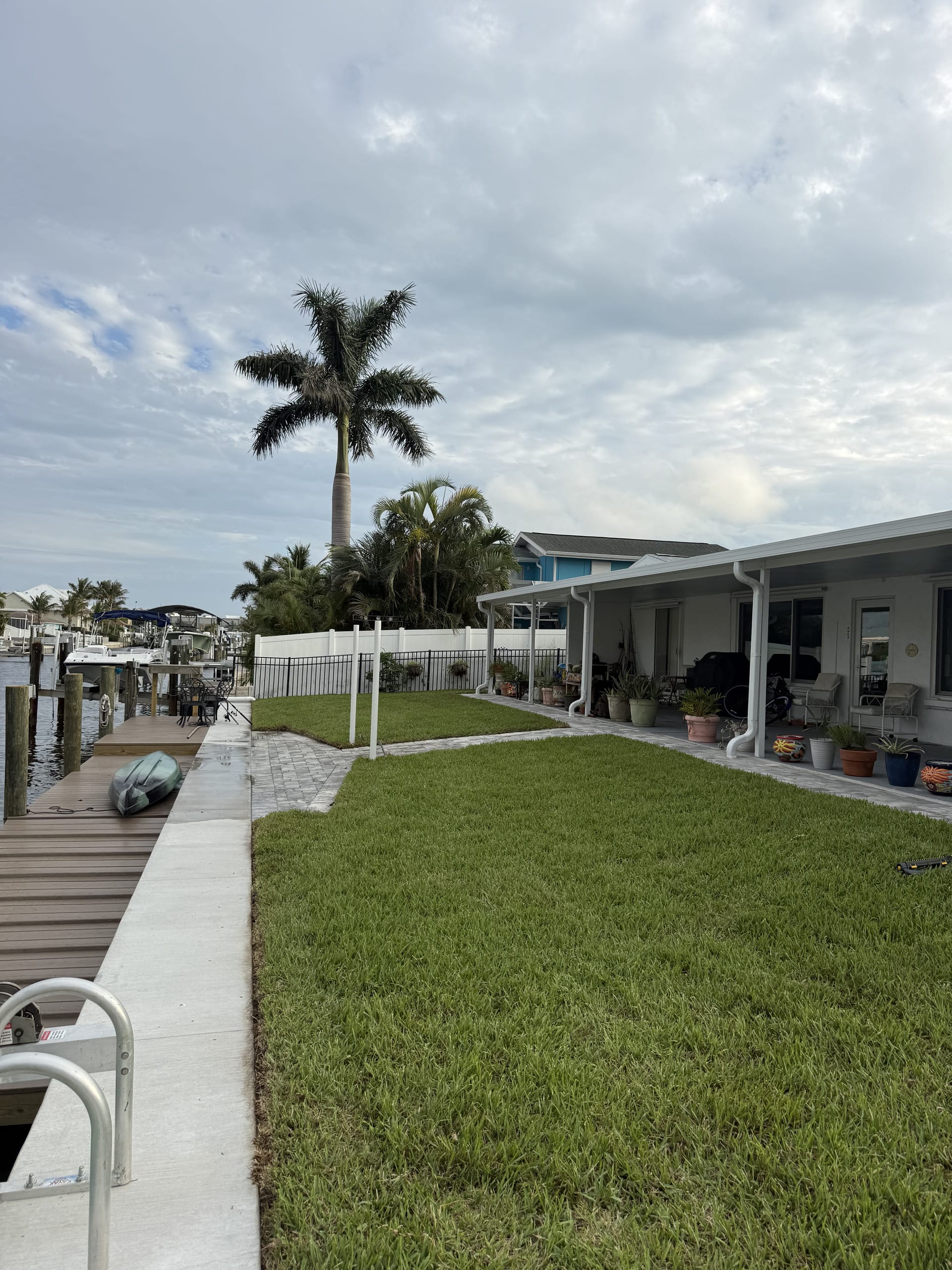 Completed waterfront backyard with fresh sod lawn and boat dock landscaped by Collica's Landscaping